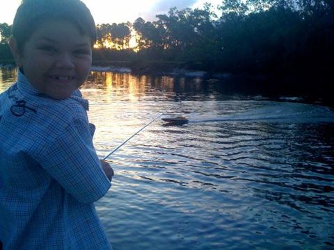 My son with the remote control for his boat, scooting along the water at the back of our property. Fun times with the family.