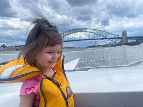 Mila, life jacket on, Harbour Bridge behind